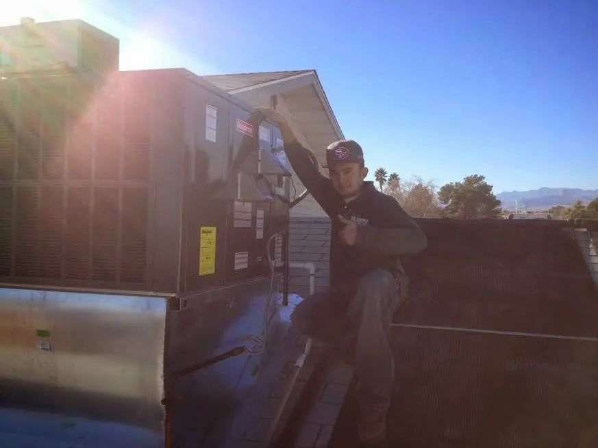 HVAC technician performing Heat Pump Repair on a rooftop unit in Parker